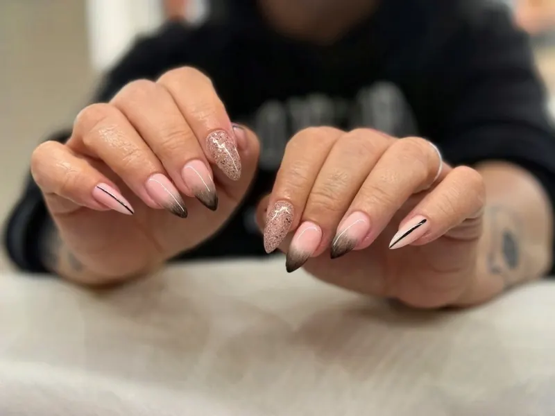 Pink-to-black ombre tips with glitter accents
